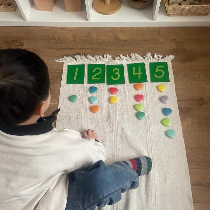 A child matching counters to number cards one to five
