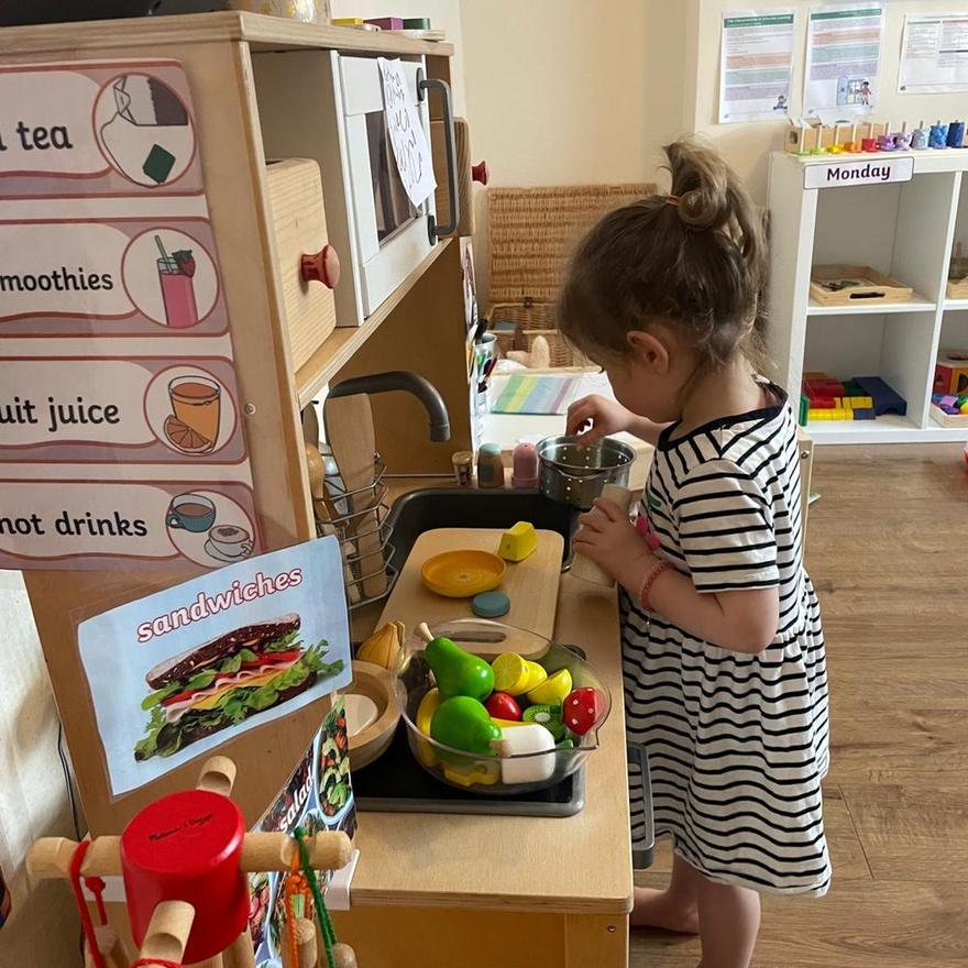 A child preparing wooden food at the play kitchen