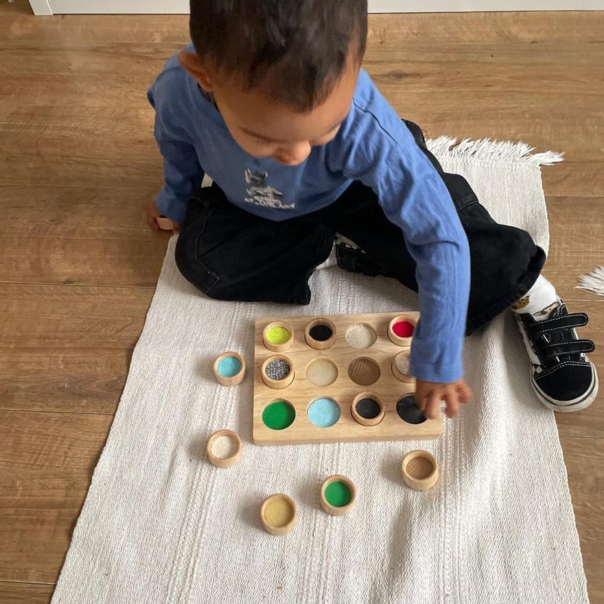 A child matching textures on a wooden board